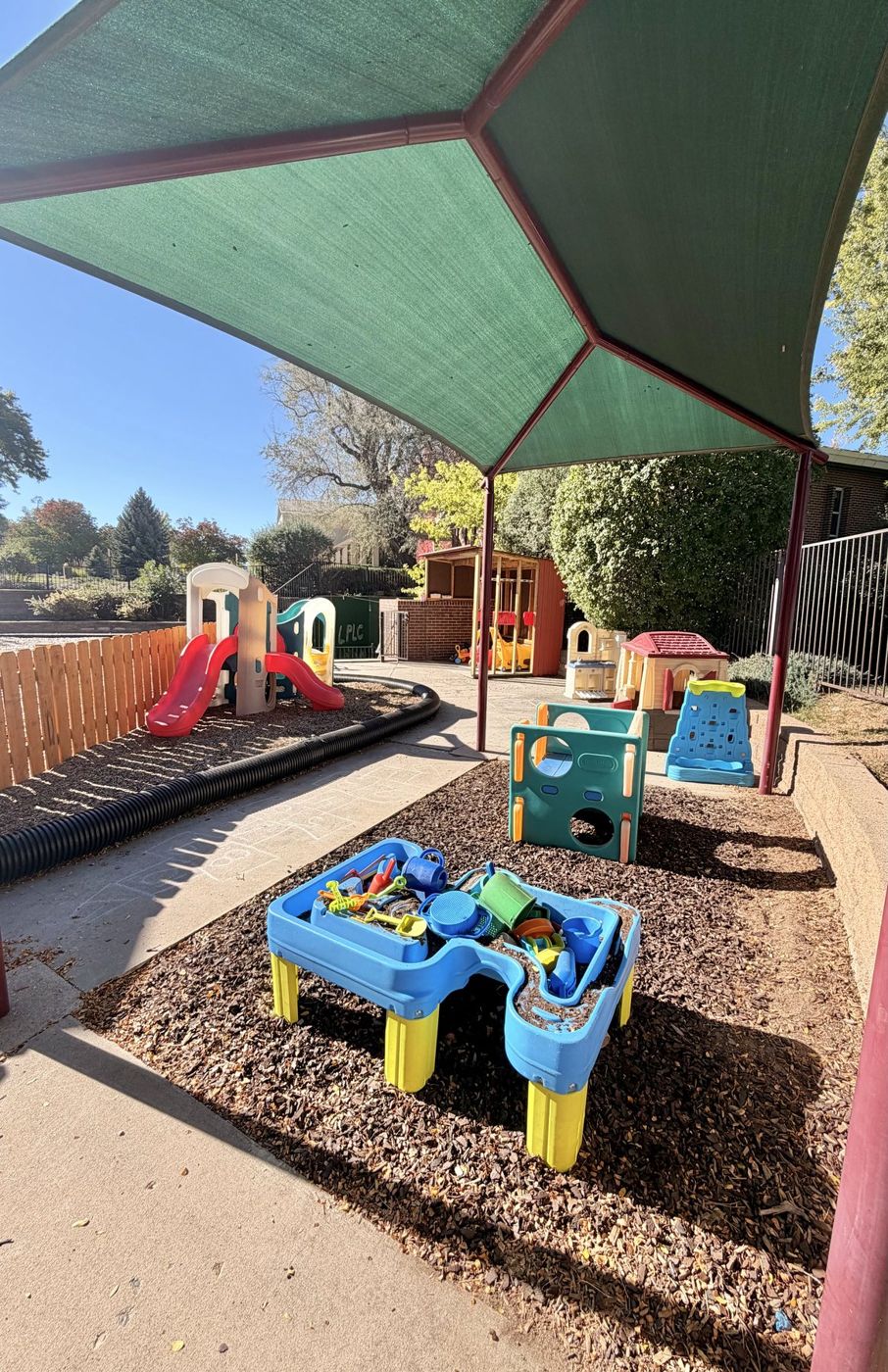 A sand and water table under a shade canopy